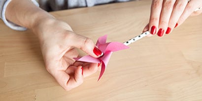 take a short flat pin and push into a paper straw, securely attaching your pinwheel